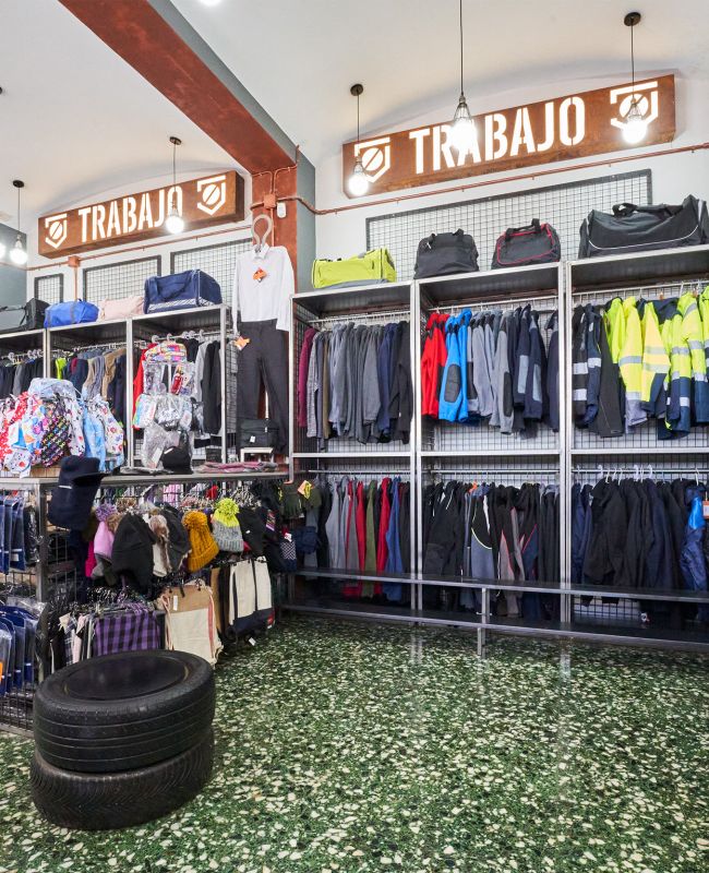 Interior de tienda LABORAL en Teruel, con estanterías llenas de ropa de trabajo, chaquetas reflectantes, mochilas, gorros y accesorios para profesionales.