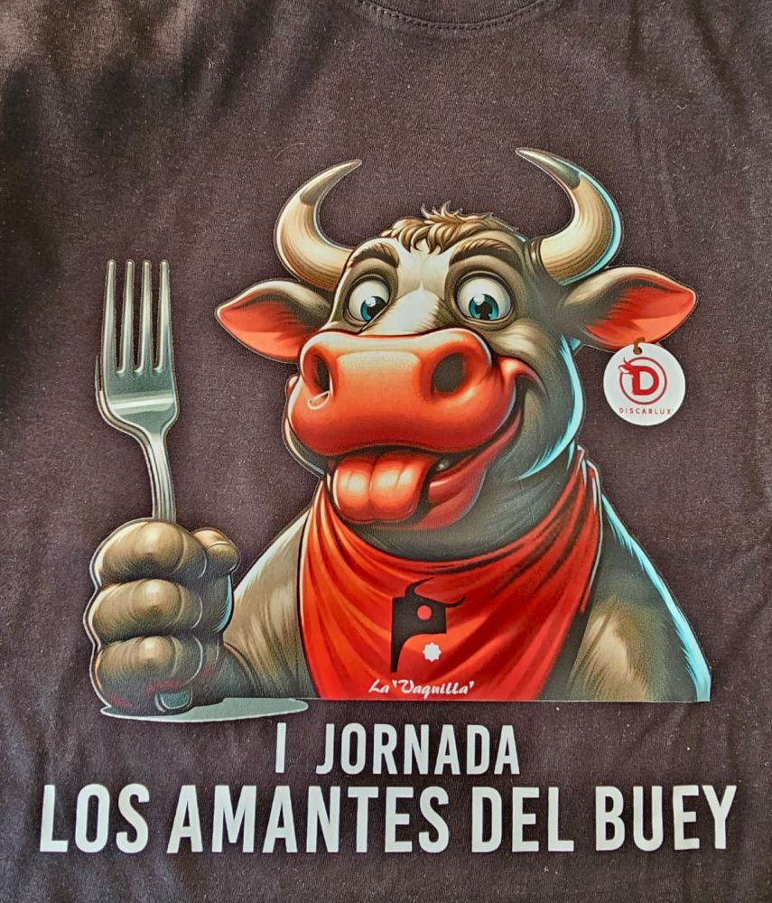 Camiseta negra con ilustración de un toro sonriente con pañuelo rojo y tenedor en la mano, junto al texto "I Jornada Los Amantes del Buey" y logotipo de Discarlux.