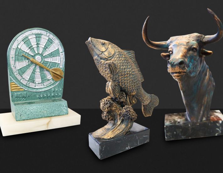 Imagen de tres trofeos de laboran , uno de juegos de dardos, otro de pesca y otro de un toro